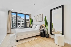 Elegance and ease go hand-in-hand in this bedroom with captivating urban vistas.