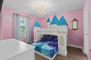 Princess castle bed with a twin over full bed and a 50" TV