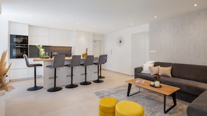 Modern eingerichtetes Wohnzimmer und voll ausgestattete Küche im Luxusapartment Silvery Split