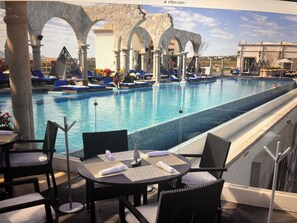 Roof top Pool, lounge area, bar, and exercise room in the corner