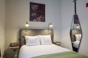 Bedroom with plush bedding and ambient wall sconces for a cozy night in