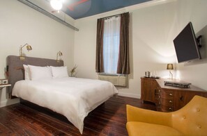 Warm bedroom featuring ample natural light and a relaxing seating area