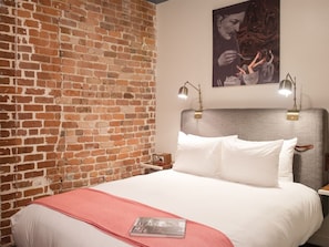 Warm-toned bedroom with brick accent wall and comfortable reading nook
