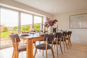 Monterey House, Thornham: Stunning views from the dining table, and bi-fold doors to the garden