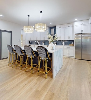 Beautiful Chefs Kitchen with 6 foot Waterfall Island, wine fridge built in Trash, Farmhouse sink, Seats 4-6 Open to dining and living room.