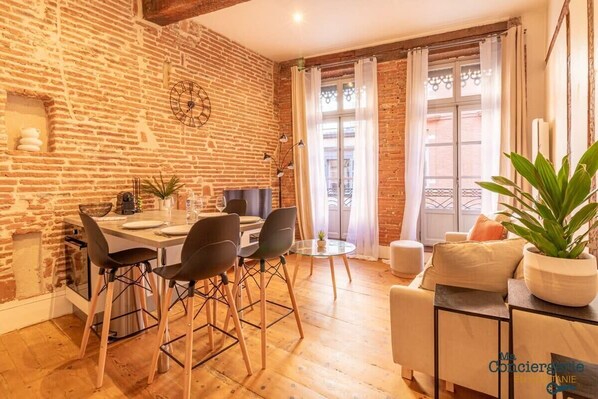 espace séjour avec canapé lit, télévision et coin repas
