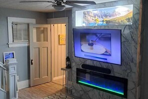 The front room features a futuristic LED-style "fireplace" and large Smart TV.