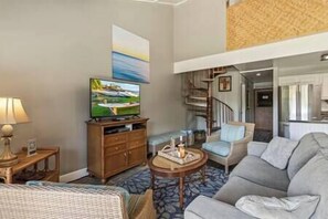 Living area features smart TV with cable, ceiling fan, and plenty of seating