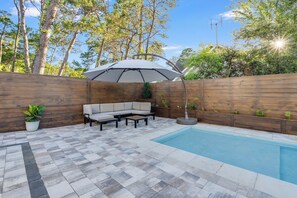  outdoor patio w/ private saltwater pool, seating area, and large umbrella.