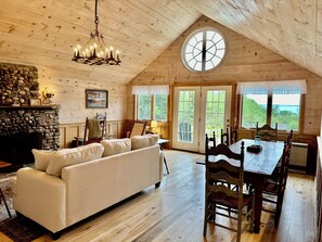 The great room has a large stone fireplace, lots of seating, and a water view!
