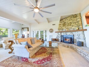 Living room with fireplace and lots of windows overlooking the mountains. 