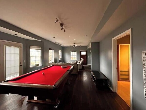 Main living room with pool table with front and side entrance to both decks