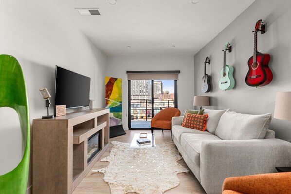 Living room with  full sleeper sofa, TV, games, and access to a private balcony
