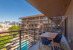 Private balcony with pool side view, dining table for 6, and lounge