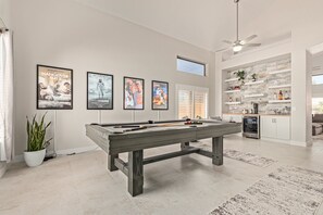 Trendy, movie themed game room with a pool table for entertainment, bar, mini fridge and chairs making it a perfect place to hang out.