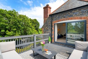 The Little Hawthorns, Roserrow, First Floor: Large decked terrace overlooking the spacious garden with outdoor furniture; access is via the first floor.