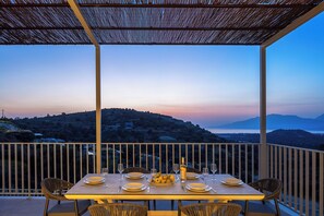 An outdoor dining table for 8 guests under a shaded pergola