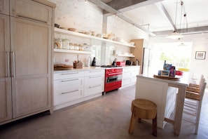 Large, professional chefs kitchen with 2 gas stoves. Open plan to dinning area