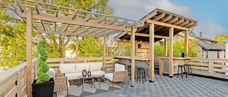 Spacious rooftop deck featuring comfortable seating and a sleek bar, perfect for entertaining and enjoying the views.