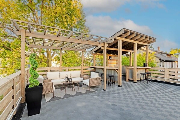 Spacious rooftop deck featuring comfortable seating and a sleek bar, perfect for entertaining and enjoying the views.
