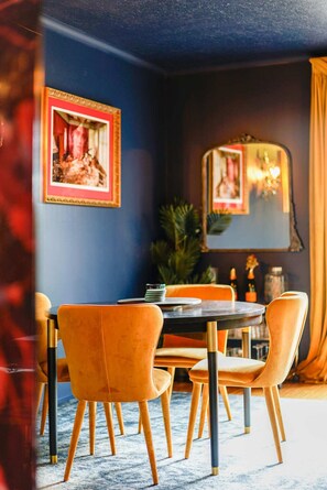 The apartment features a fully equipped kitchen for culinary enthusiasts, a cozy dining area for four, and a private enclosed courtyard with outdoor lounge furniture