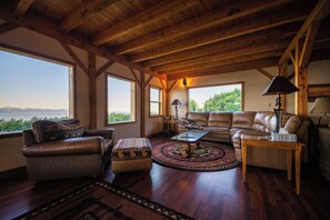 Living room with fireplace, comfy pull out couch, reading chair, and more views.
