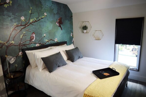 Beautiful queen-sized bed in the South Bird Suite, with a view to the front of the property.