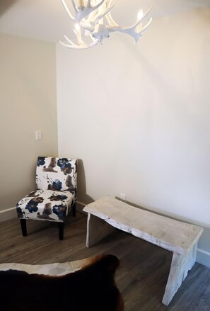 Chair and bench for extra space and storage. Featuring faux antler chandelier in the room's center.