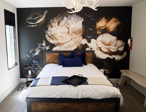 A luxurious queen-sized bed anchored by a bench and bedside table for extra storage space and seating.