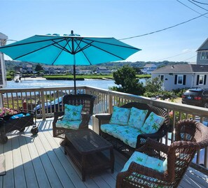 Riverfront deck with wicker furniture & umbrella.