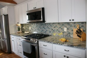 Beachy kitchen with modern appliances & ample counter.