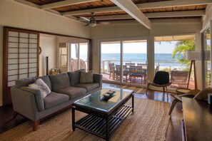 Relax in this well-furnished living room with plush seating and stunning ocean vistas