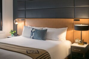 A snug bedroom haven with crisp linens, muted tones, and a splash of color for a tranquil ambiance.