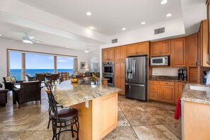 The gourmet kitchen is equipped with granite countertops, professional-grade appliances, and a spacious island