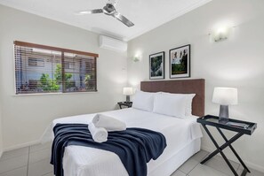Retreat to the cozy bedroom, featuring a comfortable queen-size bed and ample storage. 