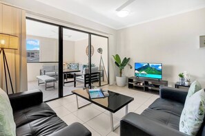 The living area extends to an enclosed balcony through sliding doors.