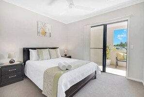 The breezy second bedroom houses a queen size bed and offers direct access to the balcony.