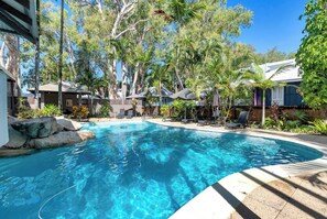 Take a dip in the building’s shared outdoor pool, surrounded by lush greenery and sun loungers for your relaxation.