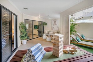 Featuring an undercover seating area, space for alfresco dining, and a turf-lined courtyard with loungers, it's perfect for soaking up the tropical sun or enjoying a game.