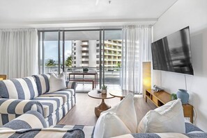 The open-plan living and dining area flows to the balcony, filling the space with natural light and ocean breezes.
