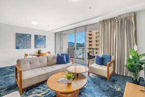 Bright and inviting, the living room offers a cosy retreat with a comfortable sofa, flat-screen TV, and stunning views of the Cairns inlet. 