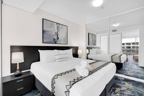 Retreat to the comfortable bedroom, featuring a king-sized ensemble bed and large mirrored built-in robes.