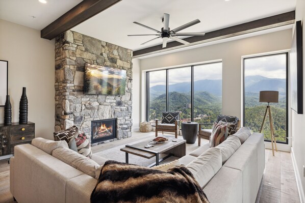 Three Bedroom Vacation Condo Rental Gatlinburg Tennessee The Hig - Spacious and Scenic Living Room with Stone Fireplace, Floor to Ceiling Windows with Smoky Mountain View, Smart TV's and WiFi throughout vacation condo