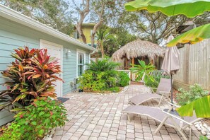 Two chaise lounges in the backyard with umbrella.