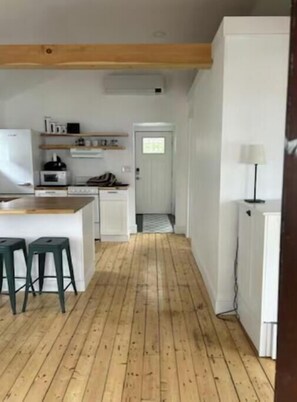 Front entrance off of sun porch to kitchen with Murphy sideboard on right