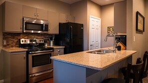 Well-appointed kitchen with granite countertops standard-sized fridge/freezer, stove, oven, microwave, dishwasher, and Bunn coffee maker and grinder.