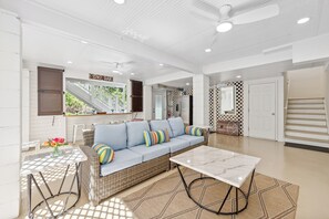 Outdoor deck seamlessly merges to the covered area with a lounge, bar and garage access.
