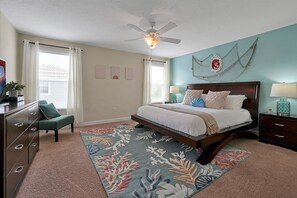 Master's bedroom with king bed, ceiling fan, TV, and windows with curtains