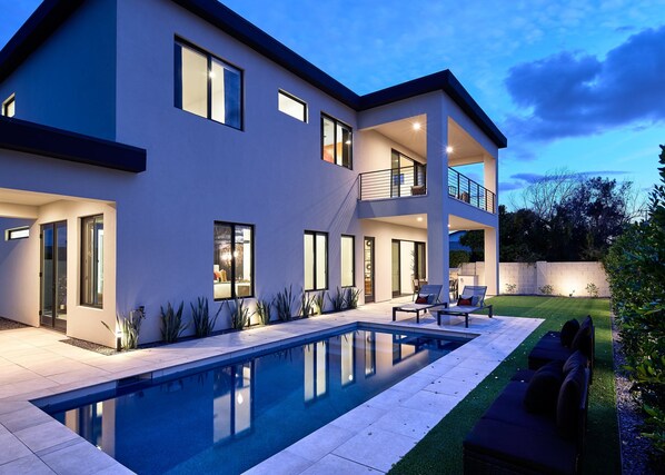 Private outdoor space with heated pool, sun loungers, outdoor dining, built-in BBQ grill, and gorgeous mountain views.