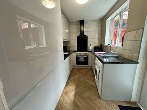 New kitchen with washing machine and oven. 